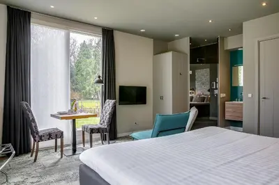 a hotel room with a bed and a table and chairs at Boutique Hotel 't Vosje in Haarlem