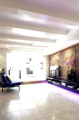 a living room with a couch and a brick wall at Amsterdam Boutique Apartments in Amsterdam