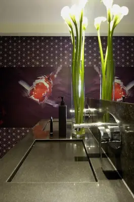 a sink with a vase with white flowers in it at Amsterdam Boutique Apartments in Amsterdam