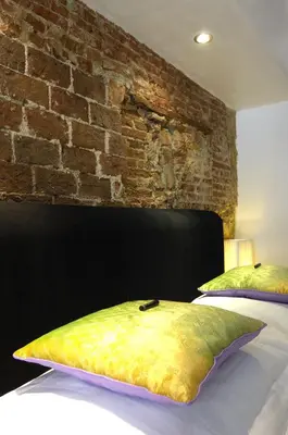 a bedroom with a bed with a brick wall at Amsterdam Boutique Apartments in Amsterdam
