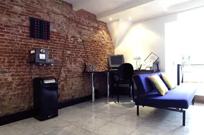 a living room with a brick wall and a blue couch at Amsterdam Boutique Apartments in Amsterdam