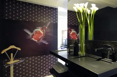 a bathroom with a sink and a vase with flowers at Amsterdam Boutique Apartments in Amsterdam