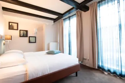 a bedroom with a large bed and large windows at Hapimag Apartments Amsterdam in Amsterdam