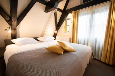 a bedroom with two beds with pillows and a window at Hapimag Apartments Amsterdam in Amsterdam