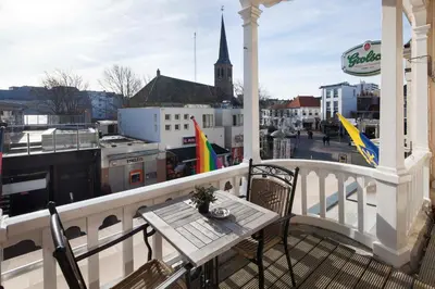 a table on a balcony with a view of a city at Hotel Grand Cafe Deight in Zandvoort