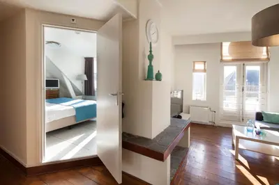 a room with a bed and a living room at Hotel Grand Cafe Deight in Zandvoort