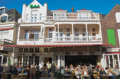 a group of people sitting at tables in front of a building at Hotel Grand Cafe Deight in Zandvoort