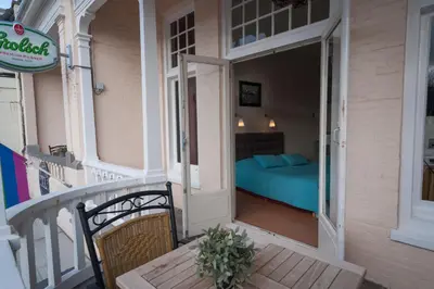 a balcony of a house with a bed in a room at Hotel Grand Cafe Deight in Zandvoort