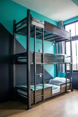 two bunk beds in a room with a green wall at Amsterdam Hostel Leidseplein in Amsterdam