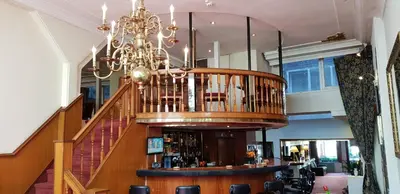 a chandelier hangs above a bar in a building at Rembrandtplein Hotel in Amsterdam