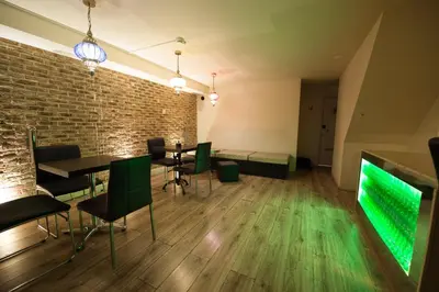 a room with tables and chairs and a green screen at Rembrandtplein Hotel in Amsterdam