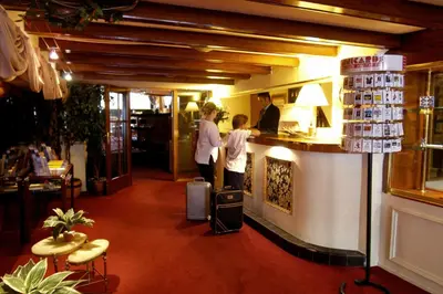 a group of people standing at a counter in a restaurant at Rembrandtplein Hotel in Amsterdam