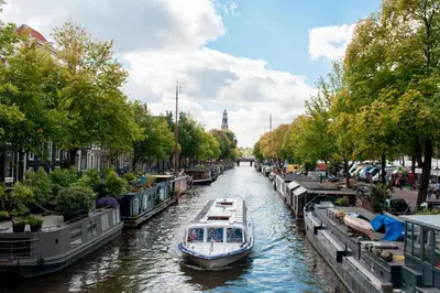 a boat traveling down a canal in a city at Way Up Studio in Amsterdam
