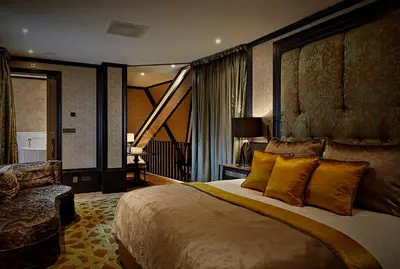 a hotel room with a large bed and a chair at Hotel TwentySeven - Small Luxury Hotels of the World in Amsterdam
