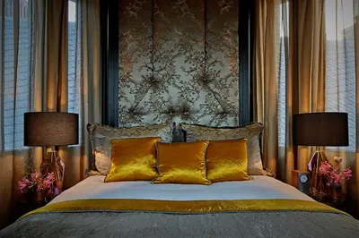 a bedroom with a large bed with two lamps at Hotel TwentySeven - Small Luxury Hotels of the World in Amsterdam