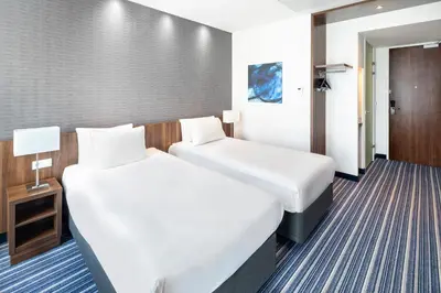 a hotel room with two beds and a door at Holiday Inn Express Amsterdam - Schiphol by IHG in Hoofddorp