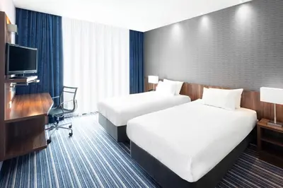 a hotel room with two beds and a television at Holiday Inn Express Amsterdam - Schiphol by IHG in Hoofddorp