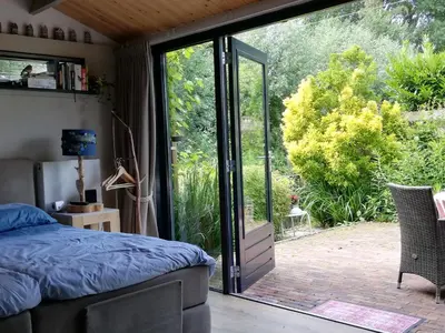 a bedroom with a bed and a sliding glass door at De Zes Wielen in Alkmaar