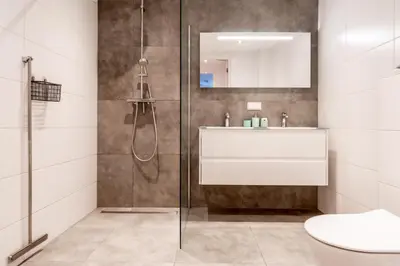 a bathroom with a shower and a sink and a toilet at Huize Mare Appartementen in Bergen aan Zee