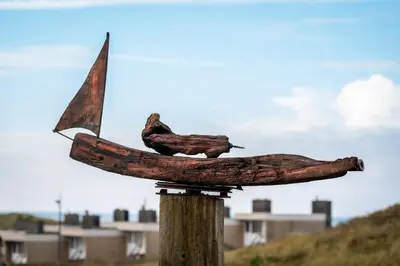 two birds sitting on top of a pole at Huize Mare Appartementen in Bergen aan Zee