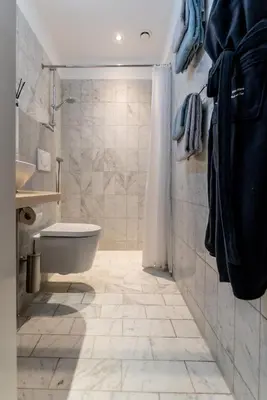 a bathroom with a shower and a toilet and a sink at Huize Mare Appartementen in Bergen aan Zee