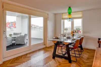 a dining room with a table and chairs and a large window at Huize Mare Appartementen in Bergen aan Zee