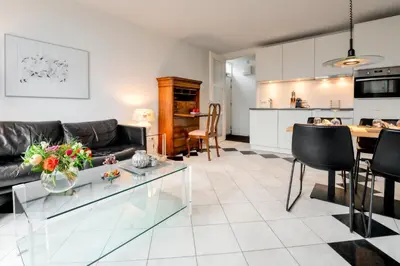 a living room and kitchen with a glass table at Huize Mare Appartementen in Bergen aan Zee