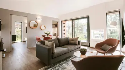 a living room with a couch and a table at Dutchen Suitelodges Gooilanden in Loosdrecht