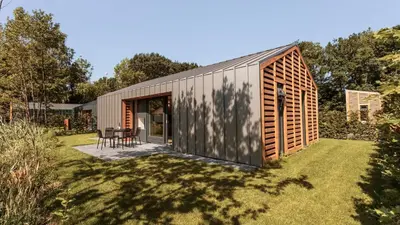 a small house in a garden with a patio at Dutchen Suitelodges Gooilanden in Loosdrecht