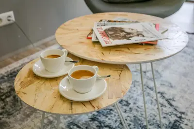 two tables with two cups of coffee and a magazine at Dutchen Suitelodges Gooilanden in Loosdrecht