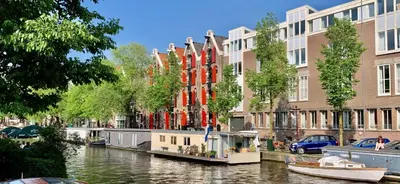 a river with buildings and boats in a city at Jordan Canal Studio in Amsterdam