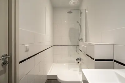 a white bathroom with a shower and a sink at Numa Amsterdam Oosterpark in Amsterdam