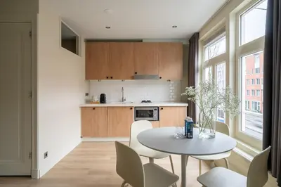 a kitchen with a table and chairs in a room at Numa Amsterdam Oosterpark in Amsterdam
