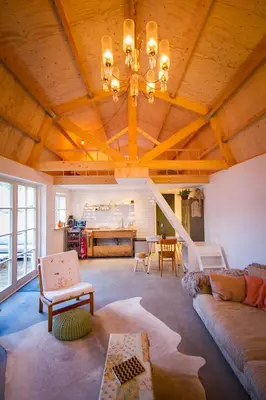 a living room with a wooden ceiling with a chandelier at Joans B&B in Zaandam
