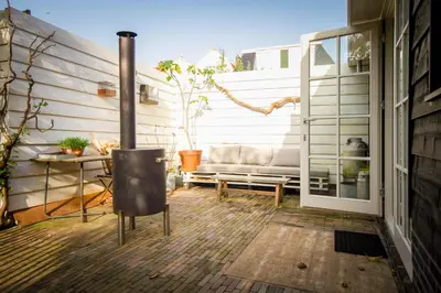 a patio with a couch and a table and a window at Joans B&B in Zaandam