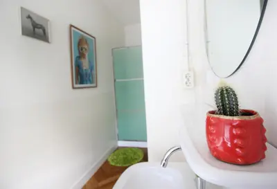 a bathroom with a cactus in a red pot on a sink at Cafe Modern in Amsterdam