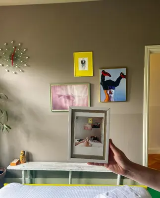 a person holding a picture frame in a bedroom at Cafe Modern in Amsterdam