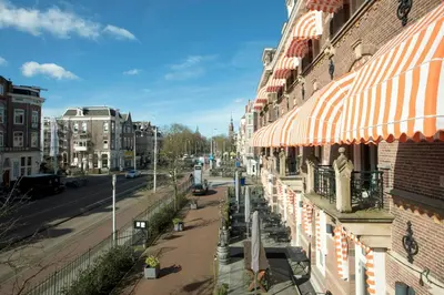a view of a street with a building with umbrellas at The Manor Amsterdam in Amsterdam