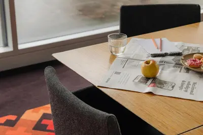 a table with a bowl of fruit on top of a newspaper at The Manor Amsterdam in Amsterdam
