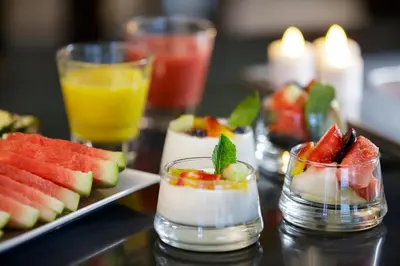 a table topped with plates of fruit and drinks at Boutique Hotel Notting Hill in Amsterdam