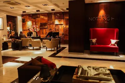 a lobby with a red chair and a restaurant at Boutique Hotel Notting Hill in Amsterdam