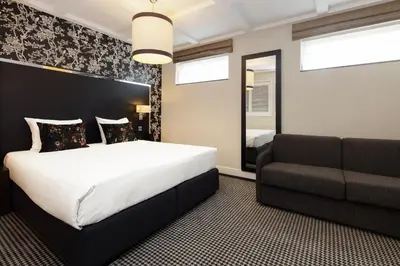 a bedroom with a bed and a couch at Boutique Hotel Notting Hill in Amsterdam