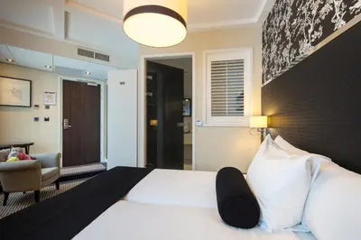 a hotel room with a bed and a chair at Boutique Hotel Notting Hill in Amsterdam