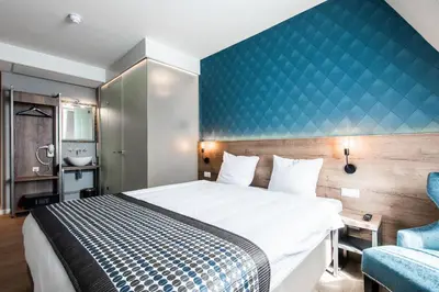 a bedroom with a large bed and a blue wall at Melrose Hotel in Amsterdam
