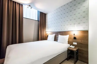 a hotel room with a white bed and a window at Melrose Hotel in Amsterdam