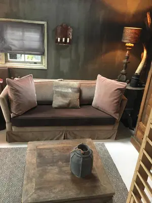 a living room with a couch and a table at De Schuilhoek Private Guesthouse in Blaricum