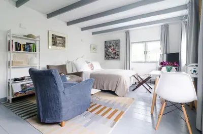 a living room with a bed and a couch and chairs at The Pool House in Den Dolder