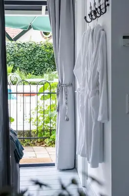 a window with white towels hanging on a curtain at The Pool House in Den Dolder