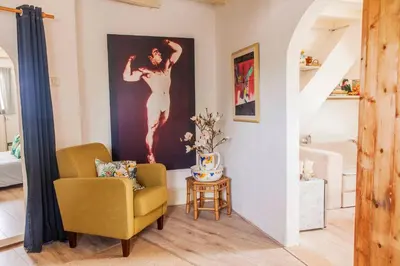 a living room with a chair and a painting on the wall at The Livingrooms Laren in Laren