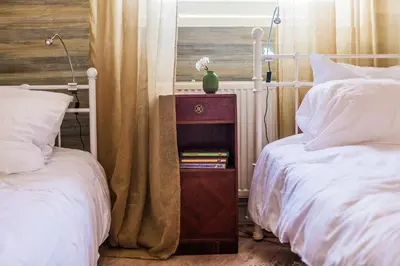 a bedroom with two beds and a night stand with books at The Livingrooms Laren in Laren
